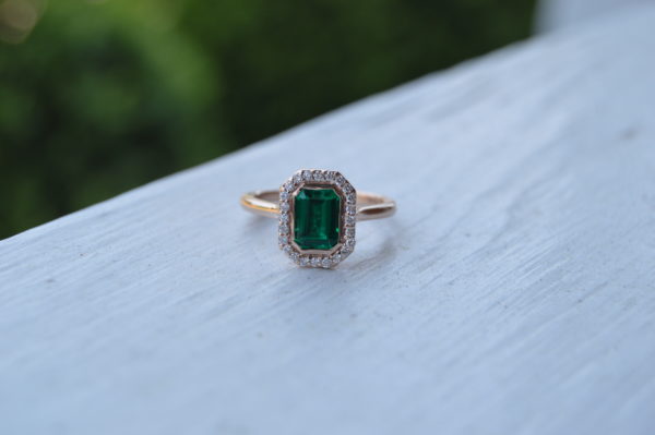Custom designed emerald cut emerald with diamond halo engagement ring in rose gold
