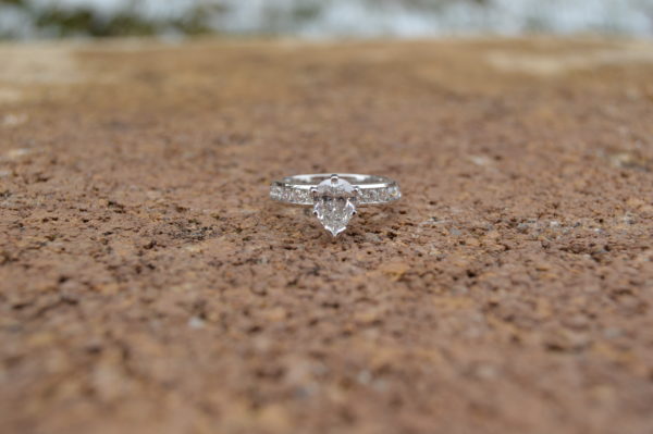 Custom designed Pear shaped diamond engagement ring with channel set round diamonds in the shank in white gold