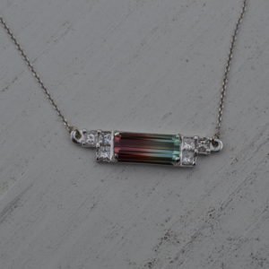 Custom designed pendant in white gold with one bicolor tourmaline (watermelon) and client's princess cut diamonds