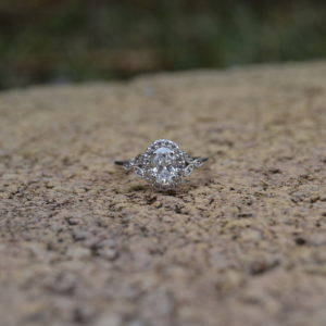 Custom designed oval diamond halo engagement ring with milgrain beading using ideal cut diamonds in white gold
