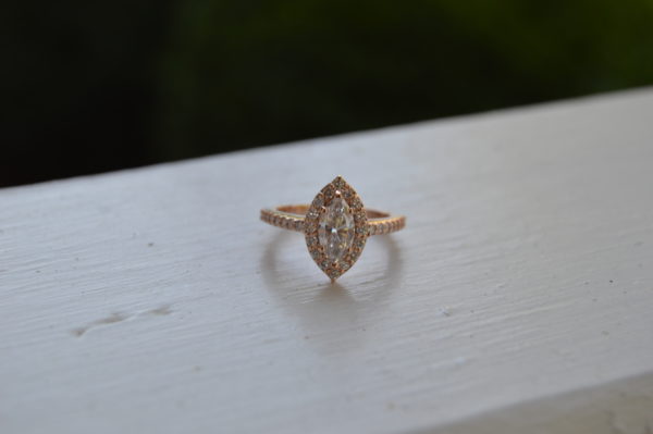 Custom designed marquise diamond halo engagement ring and diamond shank with shared prongs in rose gold