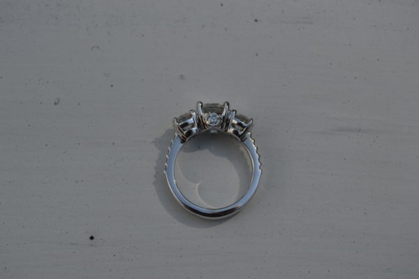 Custom designed lady's three round diamond ring with round shared prong diamond shank and diamond peek a boo in white gold