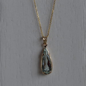 Custom designed pear shaped aquamarine pendant in yellow gold
