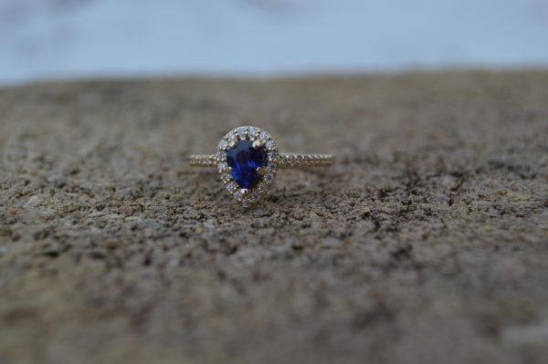 Custom Designed Ring with Pear Shaped Sapphire and Diamond Halo in Yellow Gold