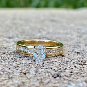 Custom Designed Yellow Gold Engagement Ring with Oval Center Diamond and Round Diamond Channel Set Shank